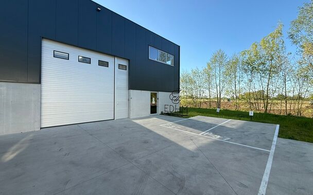Zeer goed gelegen magazijn te huur (KMO unit) van 288m&sup2; met mezzanine van 140m&sup2; en 2 parkings, gelegen op een uitstekende locatie te Lede.  Het magazijn kan gebruikt worden als opslagruimte en/of atelierruimte. De ge&iuml;soleerd loods is opgebouwd uit een 