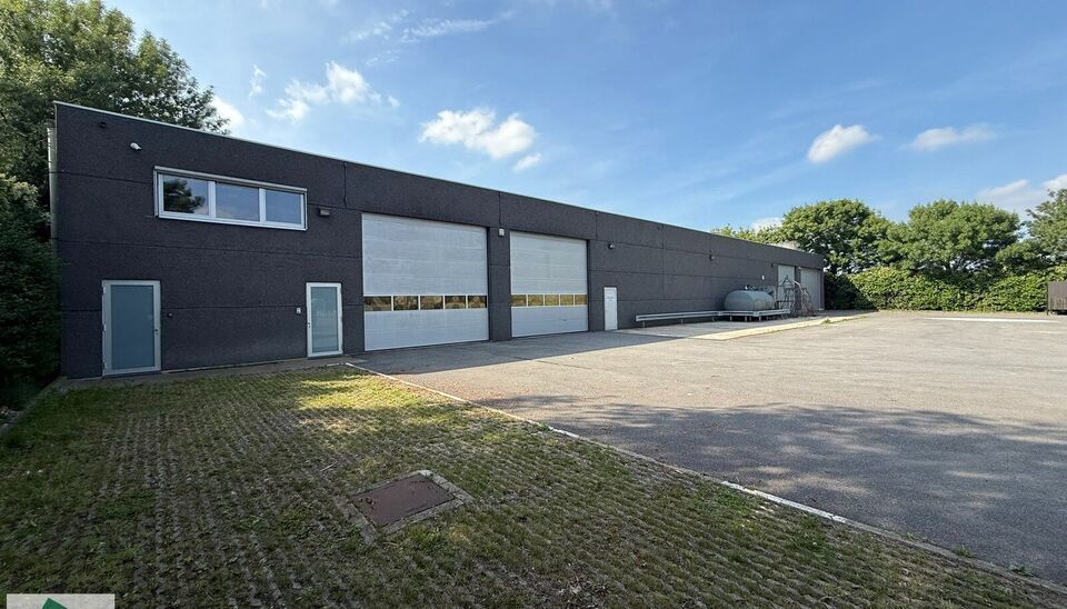 Ruime bedrijfssite met nieuwbouw kantoorgebouw, achterliggende loods van circa 1.680 m&sup2; en aansluitend weiland.
Vooraan aan de straat bevindt zich een recent en luxueus kantoorgebouw met ca. 160 m&sup2; bebouwde oppervlakte, bestaande uit gelijkvloers, eerst