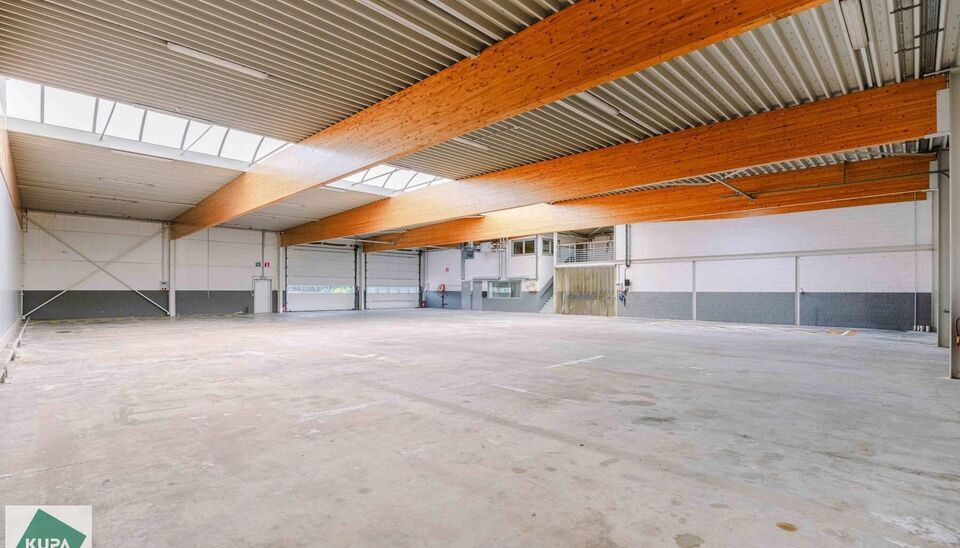 Ruime bedrijfssite met nieuwbouw kantoorgebouw, achterliggende loods van circa 1.680 m&sup2; en aansluitend weiland.
Vooraan aan de straat bevindt zich een recent en luxueus kantoorgebouw met ca. 160 m&sup2; bebouwde oppervlakte, bestaande uit gelijkvloers, eerst