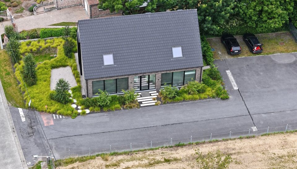 Ruime bedrijfssite met nieuwbouw kantoorgebouw, achterliggende loods van circa 1.680 m&sup2; en aansluitend weiland.
Vooraan aan de straat bevindt zich een recent en luxueus kantoorgebouw met ca. 160 m&sup2; bebouwde oppervlakte, bestaande uit gelijkvloers, eerst