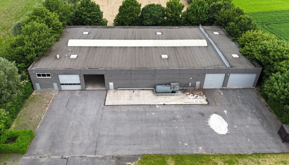 Ruime bedrijfssite met nieuwbouw kantoorgebouw, achterliggende loods van circa 1.680 m&sup2; en aansluitend weiland.
Vooraan aan de straat bevindt zich een recent en luxueus kantoorgebouw met ca. 160 m&sup2; bebouwde oppervlakte, bestaande uit gelijkvloers, eerst