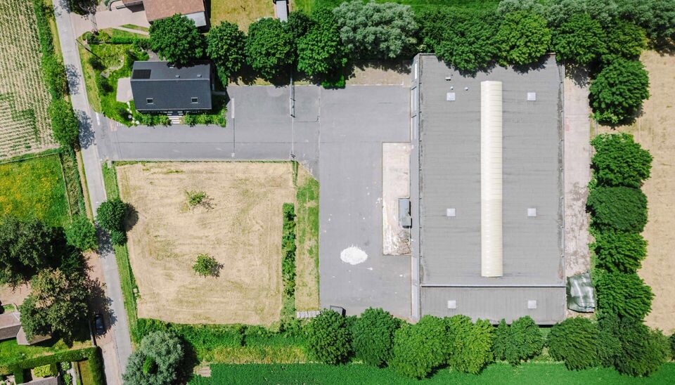 Ruime bedrijfssite met nieuwbouw kantoorgebouw, achterliggende loods van circa 1.680 m&sup2; en aansluitend weiland.
Vooraan aan de straat bevindt zich een recent en luxueus kantoorgebouw met ca. 160 m&sup2; bebouwde oppervlakte, bestaande uit gelijkvloers, eerst