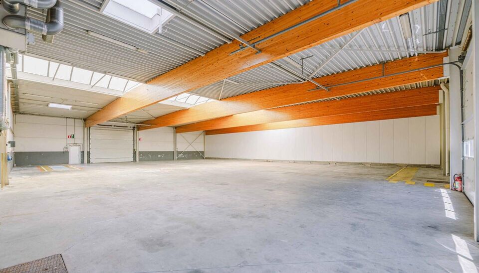 Ruime bedrijfssite met nieuwbouw kantoorgebouw, achterliggende loods van circa 1.680 m&sup2; en aansluitend weiland.
Vooraan aan de straat bevindt zich een recent en luxueus kantoorgebouw met ca. 160 m&sup2; bebouwde oppervlakte, bestaande uit gelijkvloers, eerst