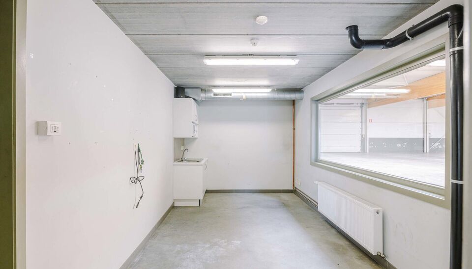 Ruime bedrijfssite met nieuwbouw kantoorgebouw, achterliggende loods van circa 1.680 m&sup2; en aansluitend weiland.
Vooraan aan de straat bevindt zich een recent en luxueus kantoorgebouw met ca. 160 m&sup2; bebouwde oppervlakte, bestaande uit gelijkvloers, eerst