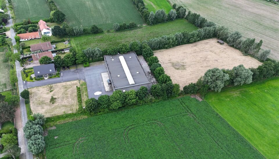 Ruime bedrijfssite met nieuwbouw kantoorgebouw, achterliggende loods van circa 1.680 m&sup2; en aansluitend weiland.
Vooraan aan de straat bevindt zich een recent en luxueus kantoorgebouw met ca. 160 m&sup2; bebouwde oppervlakte, bestaande uit gelijkvloers, eerst