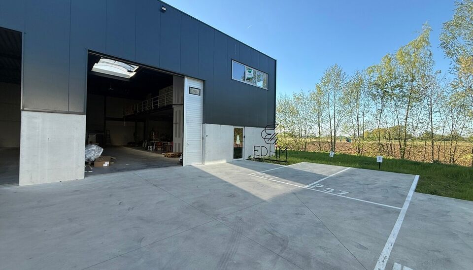 Zeer goed gelegen magazijn te huur (KMO unit) van 288m&sup2; met mezzanine van 140m&sup2; en 2 parkings, gelegen op een uitstekende locatie te Lede.  Het magazijn kan gebruikt worden als opslagruimte en/of atelierruimte. De ge&iuml;soleerd loods is opgebouwd uit een 